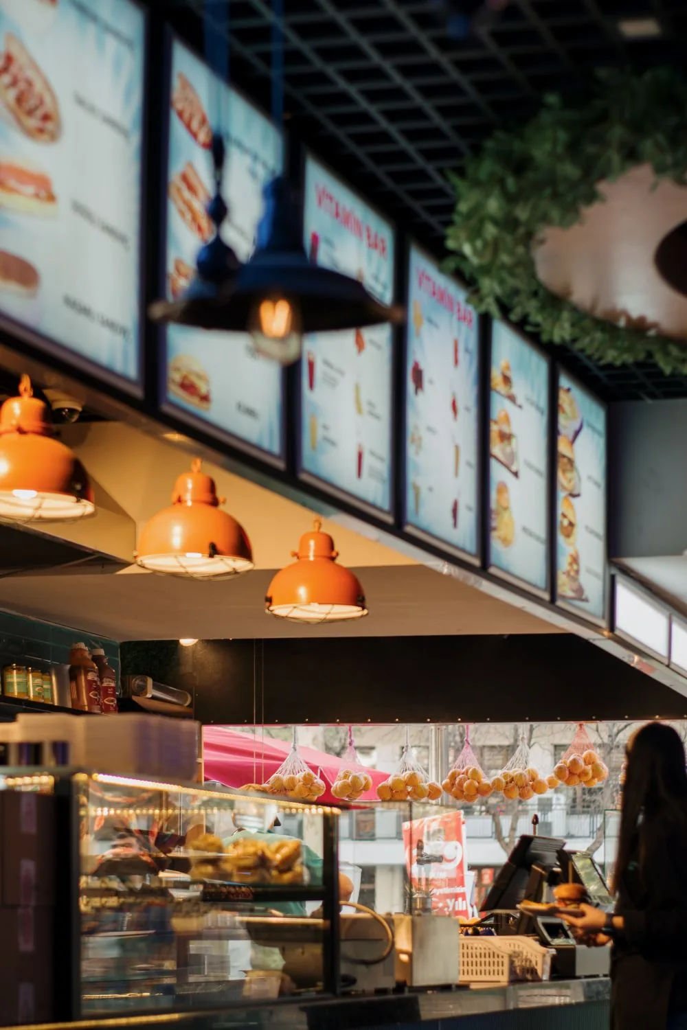 Row of illuminated menu boards above a restaurant counter