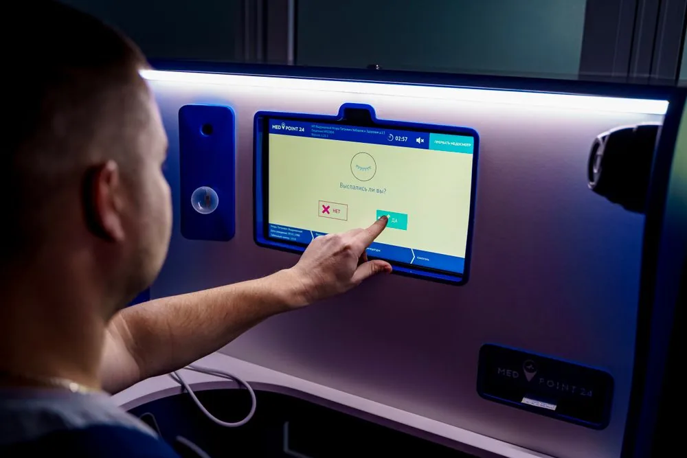 Person tapping a small wall-mounted touch panel
