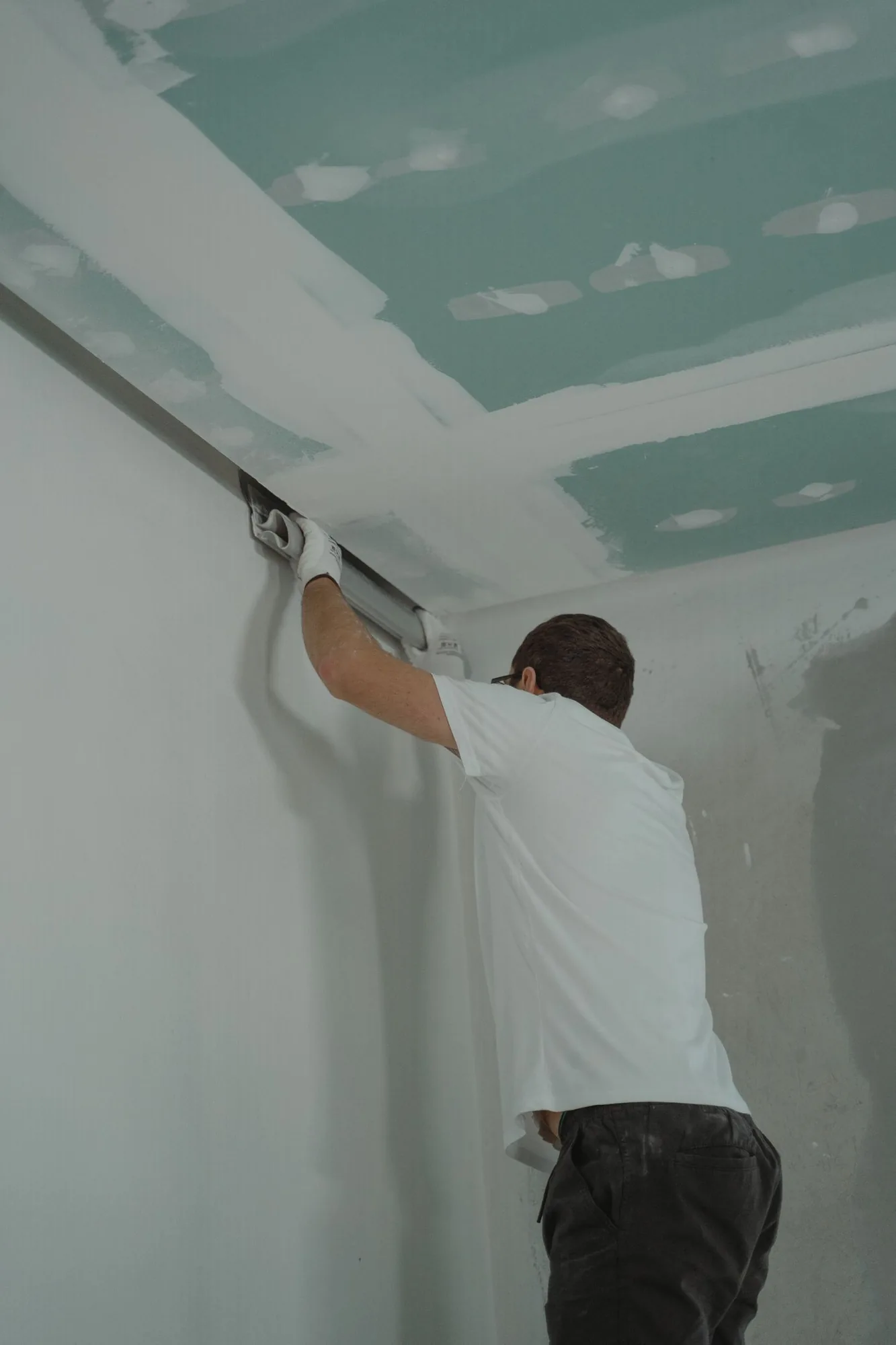 Worker finishing a drywall partition with plaster in Singapore