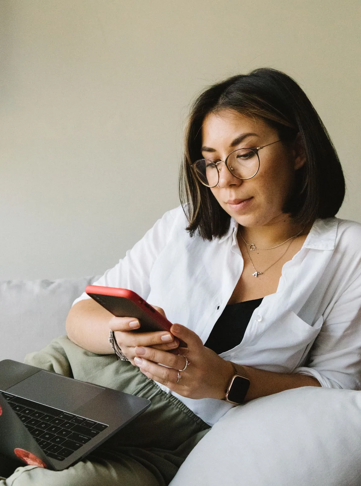 Homeowner controlling her smart aircon from a phone app on the sofa