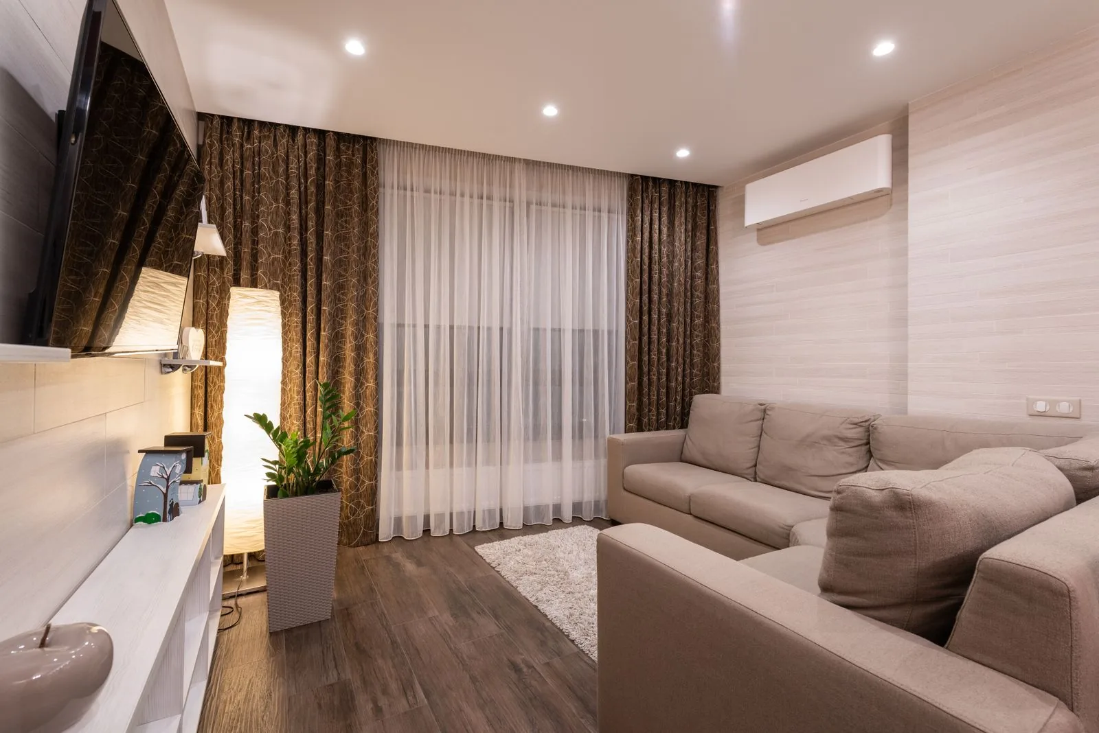 Warm Singapore living room with a wall-mounted split aircon controlled by a smart aircon system