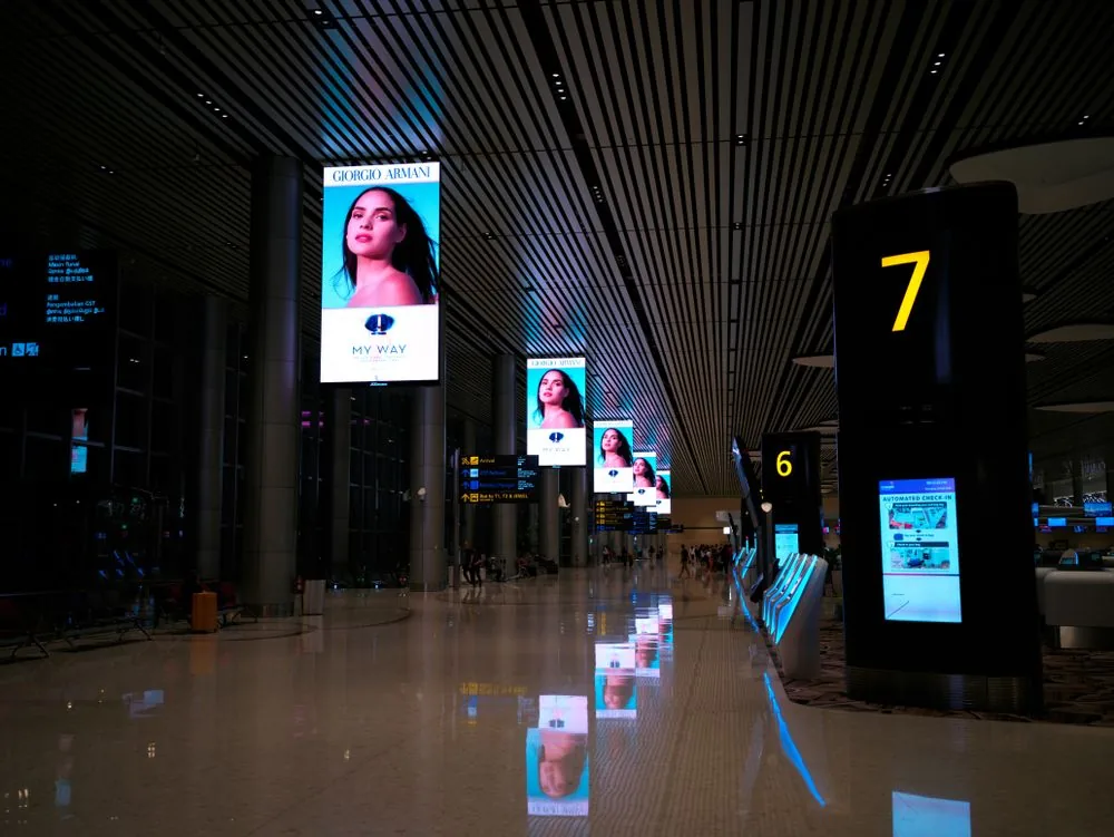 LED display columns showing brand content in a Singapore airport concourse
